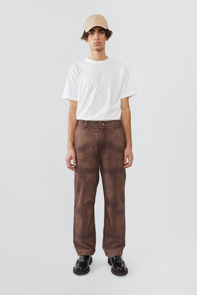 Model in Phil Suede Pants in brown by Deadwood, featuring a brushed patchwork design, made from upcycled goat suede and lined with recycled PET fabric.