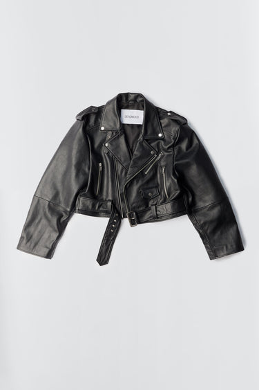 Dormi Oversized Leather Jacket in black by Deadwood. This bold, cropped biker jacket is crafted from heavy upcycled cowskin and features a boxy, oversized fit that sits just above the waist. Classic biker details include an asymmetrical front zipper, a chunky belt, a coin pocket, shoulder epaulets, and zippered cuffs and pockets. The lining is made from 100% recycled PET bottles, combining edgy style with sustainability.