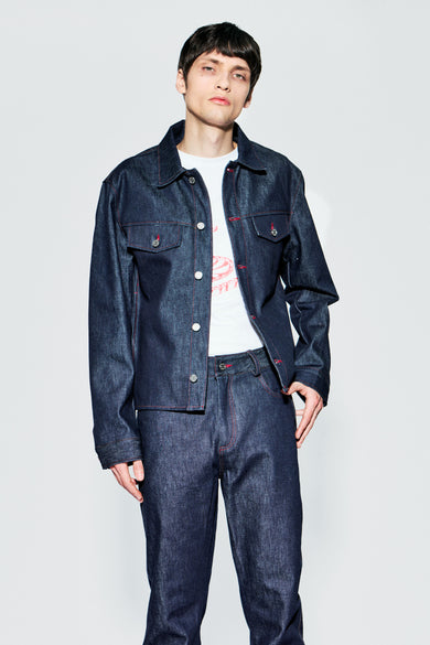 Raw denim trucker jacket worn from front on male model, showing chest pockets and fit.