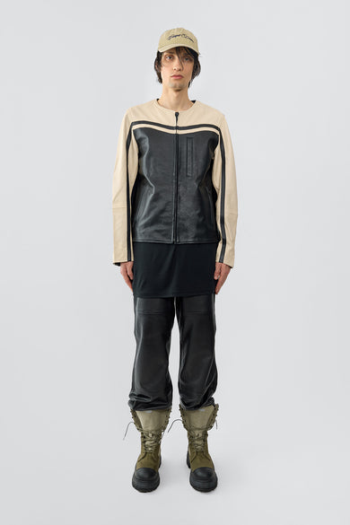 Deadwood’s Racer Jacket is a waist-length, two-tone black and off-white moto-inspired jacket made from upcycled cow leather. It features zipper waist pockets, a chest pocket, an inside pocket, and racing-inspired elbow details. Zippered cuffs add an edgy touch, while the lining is crafted from 100% recycled PET bottles for a sustainable finish.