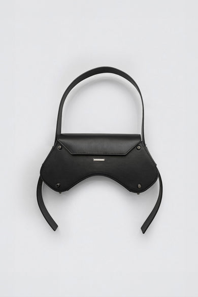 Front view of the Stella Bag in black – a sculptural shoulder bag made from upcycled leather with a curved angular silhouette and adjustable strap.