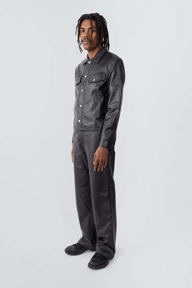 Model wearing trucker-inspired Deadwood leather jacket. It comes with button closure and flap pockets on the chest. Made from recycled leather.