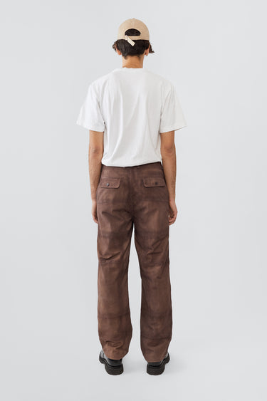 Model in Phil Suede Pants in brown by Deadwood, featuring a brushed patchwork design, made from upcycled goat suede and lined with recycled PET fabric.
