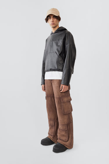 
A male model wearing the Deadwood Cargo Leather Pants. These workwear-inspired leather pants feature a wide, relaxed fit with a flowing silhouette. Designed with double waist pockets, multiple cargo pockets with hidden push-button closures, and a mid-waist zip fly. Crafted from upcycled leather and lined with fabric made from 100% recycled plastic bottles.