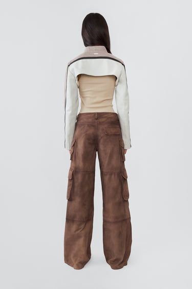 Model from the back in Sephir ultra-cropped leather jacket in white with black stripes on the sleeves. Rracer-inspired with upcycled materials and bold design