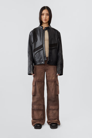 Model in Hiro black jacket, made from upcycled cow leather and goat suede, with a front zipper closure and ventilation hole.