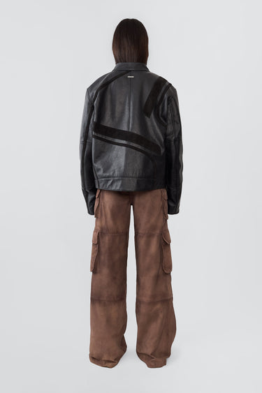 Model from the back in Hiro black jacket, made from upcycled cow leather and goat suede, with a front zipper closure and ventilation hole.