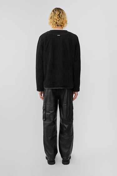 Back view of model wearing liner jacket in black suede. The jacket features upcycled suede and a front zipper closure.