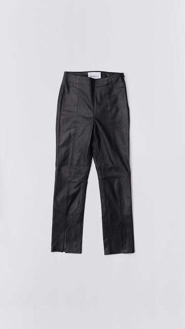 Flat view of a model wearing high-waisted pants with a slim leg and ankle-length crop. The pants feature a split hem at the front and concealed side zip closure. Made from recycled leather with a lining made from recycled PET bottles.