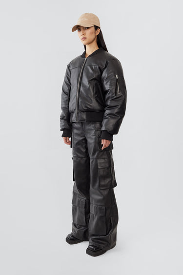 Side view of Bofinger black leather bomber jacket by Deadwood, showcasing sleeve zipper pull and ribbed cuffs, crafted from upcycled leather.
