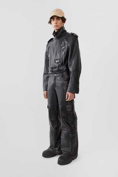 Side view of Dormi oversized black leather jacket for men by Deadwood, showcasing shoulder epaulets, zippered cuffs, and boxy fit.
