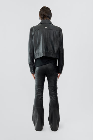 Back of model wearing Gable jacket in black, with a cropped cut and features front pockets. Made from recycled leather.