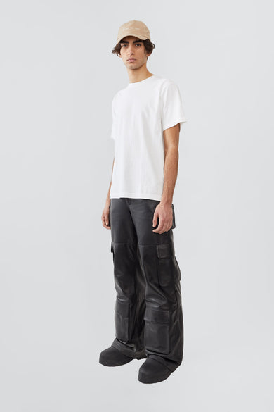 Side profile of model in black Prowess leather cargo pants, relaxed fit with multiple pockets and sustainable upcycled leather.

