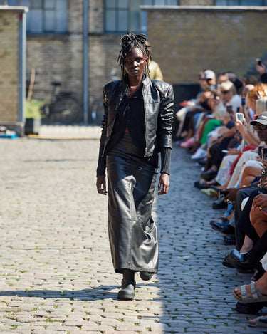 Female model on runway wearing Black Dita Detacheble Sleeves Jacket from Deadwood Spring/Summer 2025 Collection during Copenhagen Fashion Week. The look features upcycled leather and recycled cotton, reflecting the brand’s commitment to sustainable fashion