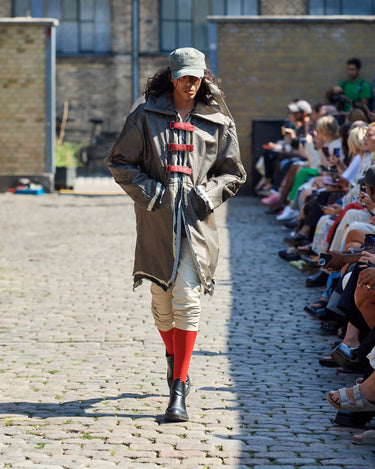 Male model on runway wearing white, grey and red outfit from Deadwood Spring/Summer 2025 Collection during Copenhagen Fashion Week. The look features upcycled leather and recycled cotton, reflecting the brand’s commitment to sustainable fashion