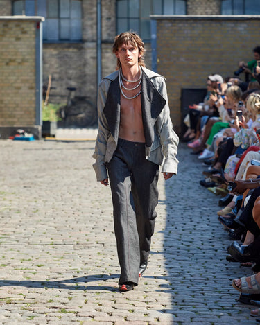 Male model on runway wearing white and black jacket and black pants from Deadwood Spring/Summer 2025 Collection during Copenhagen Fashion Week