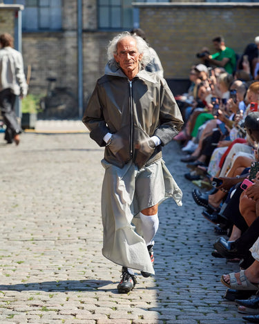 Male model on a runway wearing a brown and white outfit from Deadwood Spring/Summer 2025 Collection during Copenhagen Fashion Week. The look features upcycled leather and recycled cotton, reflecting the brand’s commitment to sustainable fashion