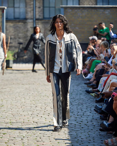 Male model on runway in Sure Strap Cotton Shirt and Racer Jacket from Deadwood Spring/Summer 2025 Collection during Copenhagen Fashion Week. The look features upcycled leather and recycled cotton, reflecting the brand’s commitment to sustainable fashion