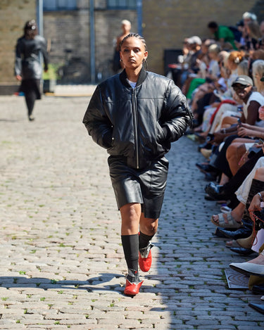 Female model on runway wearing Bofinger Padded Jacket from Deadwood Spring/Summer 2025 Collection during Copenhagen Fashion Week. The look features upcycled leather and recycled cotton, reflecting the brand’s commitment to sustainable fashion