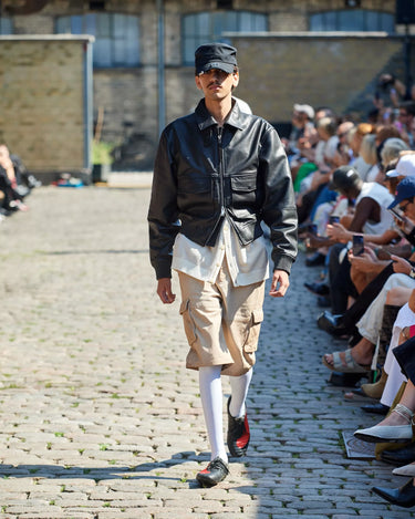 Male model on runway wearing black and beige outfit from Deadwood Spring/Summer 2025 Collection during Copenhagen Fashion Week. The look features upcycled leather and recycled cotton, reflecting the brand’s commitment to sustainable fashion