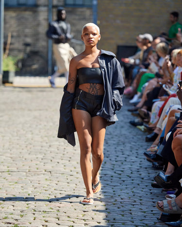 Female model on runway wearing a black leather top and denim jacket from Deadwood Spring/Summer 2025 Collection during Copenhagen Fashion Week. 