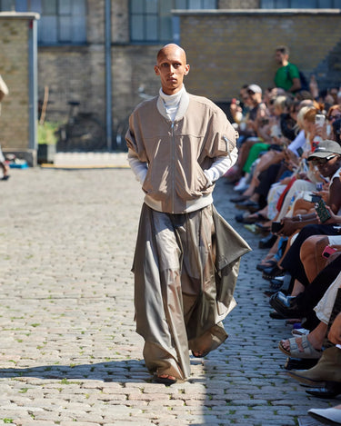 Male model on runway wearing beige leather jacket from Deadwood Spring/Summer 2025 Collection during Copenhagen Fashion Week. The look features upcycled leather and recycled cotton, reflecting the brand’s commitment to sustainable fashion