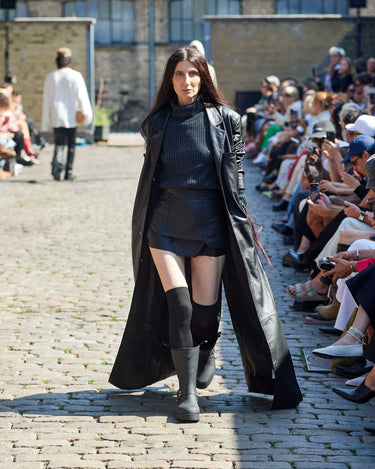 Female model on runway wearing black leather coat from Deadwood Spring/Summer 2025 Collection during Copenhagen Fashion Week. The look features upcycled leather and recycled cotton, reflecting the brand’s commitment to sustainable fashion