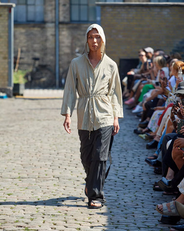 Male model on runway wearing cream and black outfit from Deadwood Spring/Summer 2025 Collection during Copenhagen Fashion Week. The look features upcycled leather and recycled cotton, reflecting the brand’s commitment to sustainable fashion