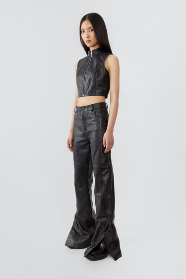 Side view of Prance black leather pants by Deadwood, showcasing leg slits and sleek bootcut silhouette.
