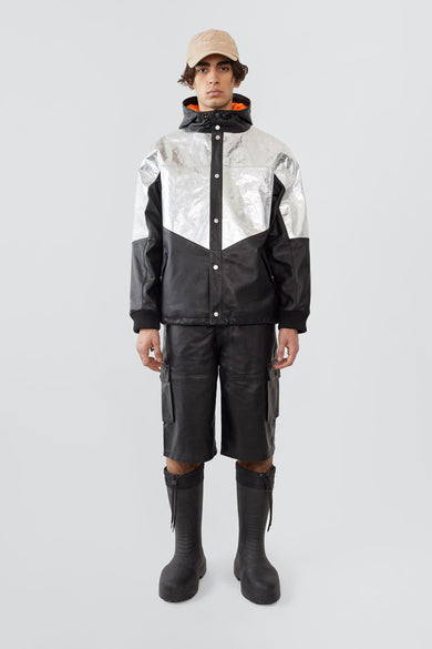 
The Tycho Jacket is a leather and aluminum parka featuring a cozy hood, orange lining, and drawstring hem for an adjustable fit. It includes side pockets, an inside pocket, and is crafted from upcycled leather, recycled polyester with an aluminum coating, and lined with recycled PET bottles for a sustainable design.