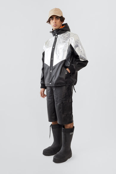 
The Tycho Jacket is a leather and aluminum parka featuring a cozy hood, orange lining, and drawstring hem for an adjustable fit. It includes side pockets, an inside pocket, and is crafted from upcycled leather, recycled polyester with an aluminum coating, and lined with recycled PET bottles for a sustainable design.