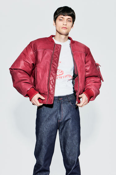 Male model wearing red upcycled leather bomber jacket, front view