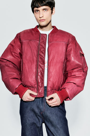 Male model wearing red upcycled leather bomber jacket with zip closure, front view
