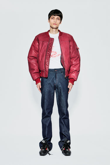 Male model wearing red upcycled leather bomber jacket, front view, full body