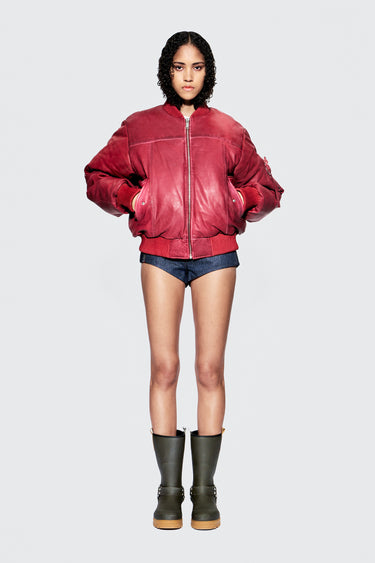 Female model wearing red upcycled leather bomber jacket, front view