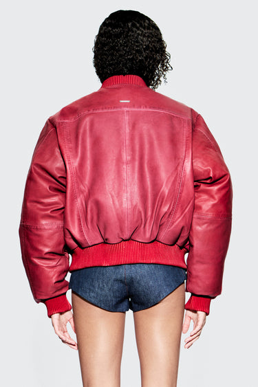 Back view of female model wearing red upcycled leather bomber jacket.