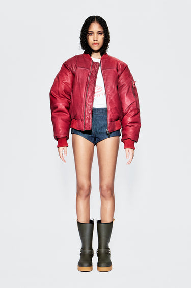 Front view of female model wearing red upcycled leather bomber jacket.