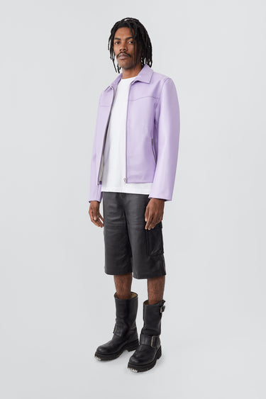 Side view of model wearing Bruno Jacket in lilac. Crafted from heavy upcycled cactus leather, this straight-cut jacket features a casual fit, waist length, front zipper closure, zipper at wrist, and a zipper pocket. Lined with fabric made from 100% recycled plastic bottles.