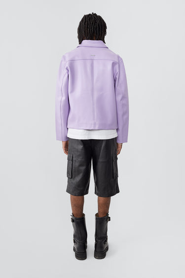 Back view of model wearing Bruno Jacket in lilac. Crafted from heavy upcycled cactus leather, this straight-cut jacket features a casual fit, waist length, front zipper closure, zipper at wrist, and a zipper pocket. Lined with fabric made from 100% recycled plastic bottles.