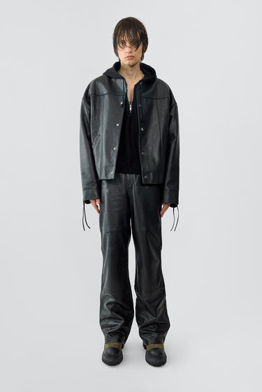 Model wearing Canoo Jacket in black upcycled leather, featuring drawstrings in cufs and duo waist pockets.