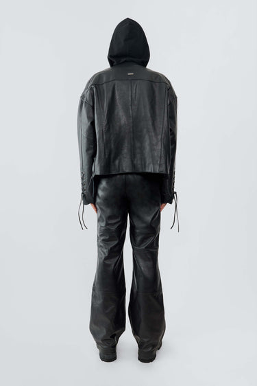 Back view of model wearing Canoo Jacket in black upcycled leather, featuring drawstrings in cufs and duo waist pockets.