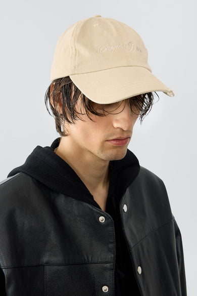 Model wearing Carpe Diem baseball cap in beige made out of recycled cotton, featuring an beige embroidery and a silver-tone buckle in the back