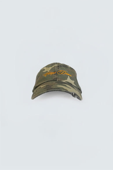 A camouflage-patterned baseball cap with 'Carpe Diem' embroidery on the front and an adjustable silver-tone buckle at the back.