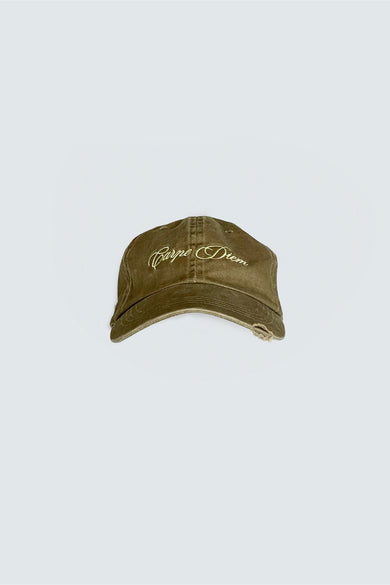 A green baseball cap with 'Carpe Diem' embroidered on the front, featuring an adjustable silver-tone buckle at the back.