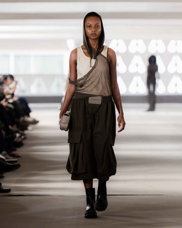 Model walking on Deadwood pre-spring 2026 runway show wearing a sleeveless top and oversized cargo shorts.