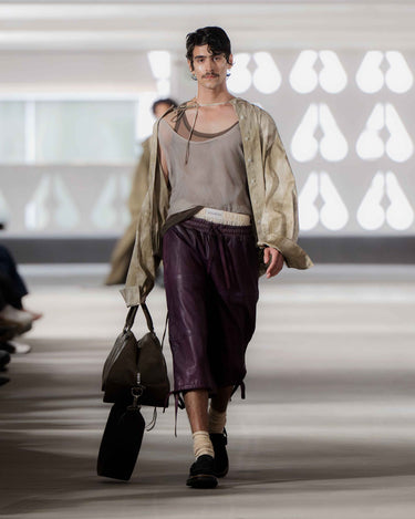 Samuel Lejon walking on Deadwood pre-spring 2026 runway show wearing a casual outfit with a jacket and purple pants. 
