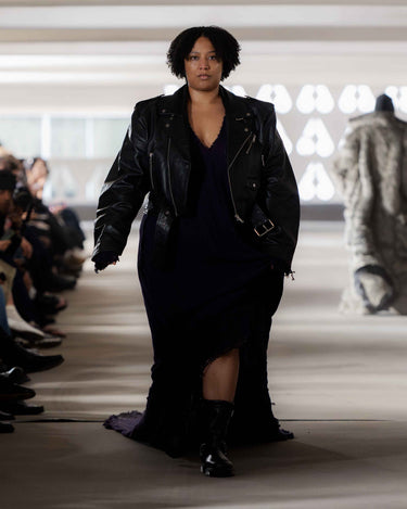 Model wearing a black leather jacket and purple knitted dress on Deadwood pre-spring 2026 runway