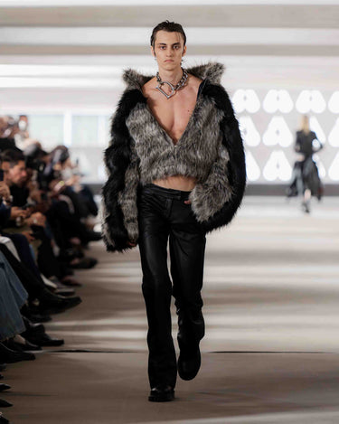 Model walking on Deadwood pre-spring 2026 runway show wearing a fur coat, Deadwood necklace and black pants.