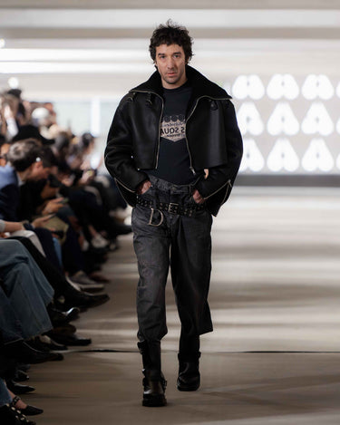 Ali Boulala walking on Deadwood pre-spring 2026 runway show wearing a black leather jacket, vintage tee and dark jeans.