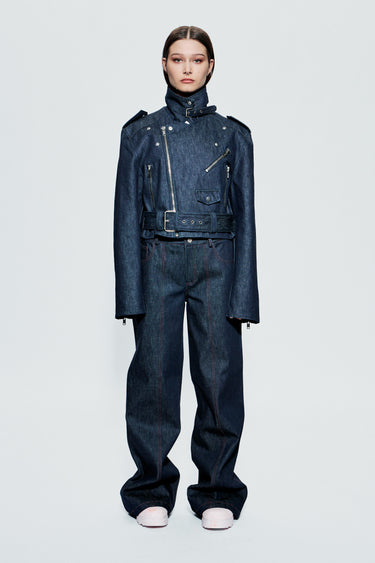 Model wearing a blue raw denim outfit on a light gray background.